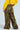 A person wearing a yellow sweatshirt and HIDDEN IN PLAIN SIGHT CARGO PANT stands with their back to the camera. These camo print, high-rise cargo pants feature multiple pockets and are set against a light blue background.