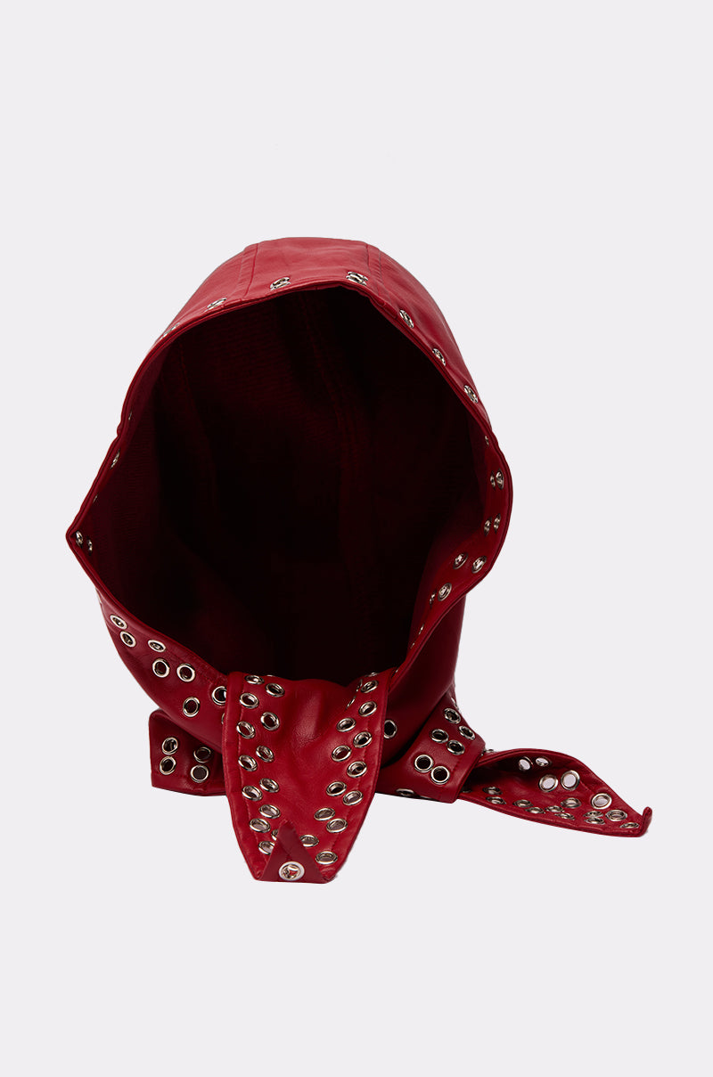 The BUCKLE UP PU HEADSCARF is a red faux leather accessory featuring silver grommet details and an attached scarf, shown against a plain light background. 4