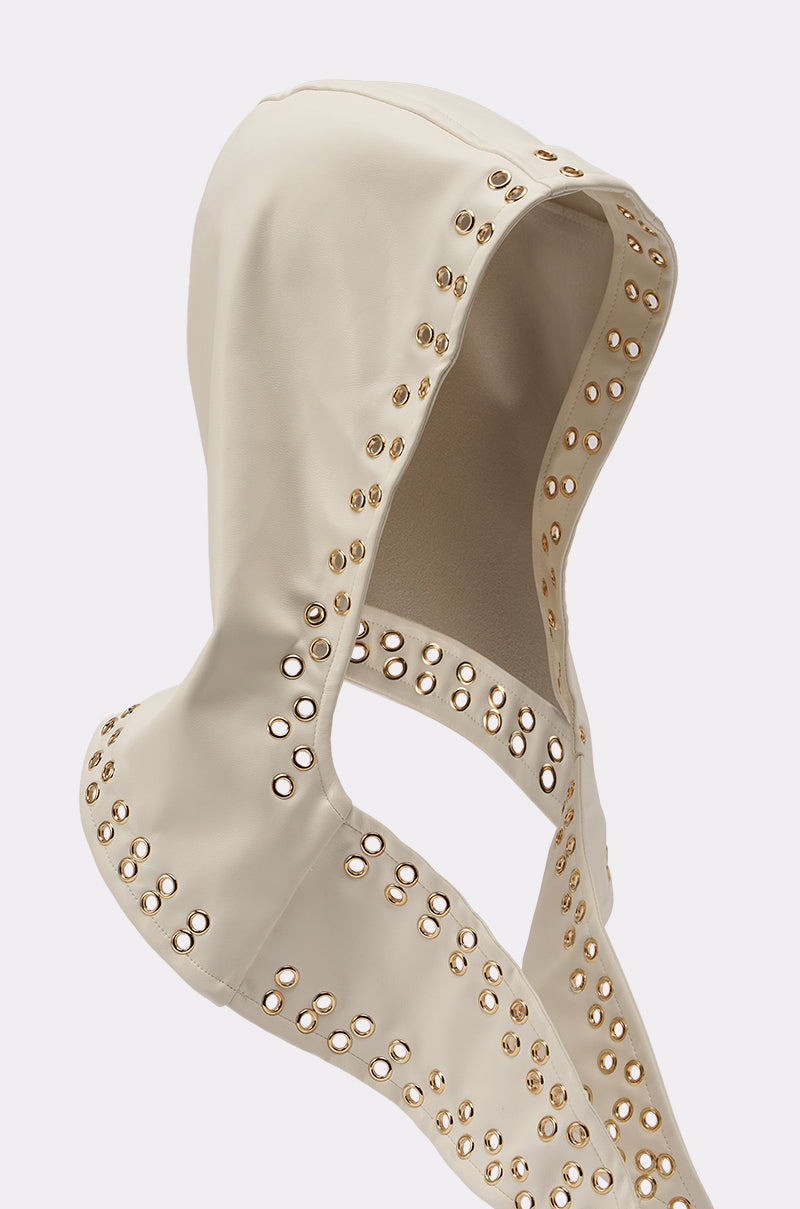 The THAT GURL PU GROMMET HEADSCARF is a beige, smooth-textured headscarf featuring bold grommet details along the edges. Inspired by streetwear, it’s showcased on a plain white background. 4