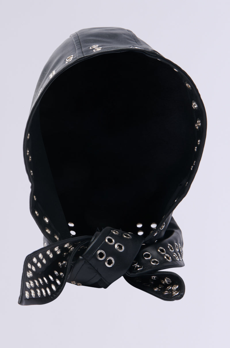 The OH SO CHIC PU HEAD SCARF from AKIRA Label is a faux leather hood featuring metal eyelets along the edges and a bow at the bottom. It has a lined interior, turned inward to emphasize its striking metal details.