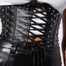 Close-up of a person wearing the BLING UNDERBUST CORSET BELT, which is adorned with silver studs and features a lace-up detail over a white top. The outfit includes black faux leather pants, creating a cohesive punk/rock aesthetic. The corset laces tightly at the front, accentuating the waistline with rhinestone embellishments.