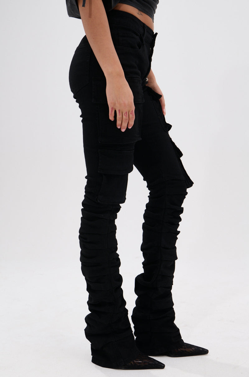 A person wears the DOUBLE VISION VINTAGE WASH DENIM PANT, featuring a skinny fit and multiple pockets, paired with pointed-toe black shoes. Only their lower body is shown against a plain white background.