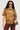 A person with long, wavy black hair wearing sunglasses and a grunge-style FREEDOM OVERSIZED TEE paired with red distressed pants. A gray bag with a gold metallic chain link hangs over one shoulder as they stand against a light background.
