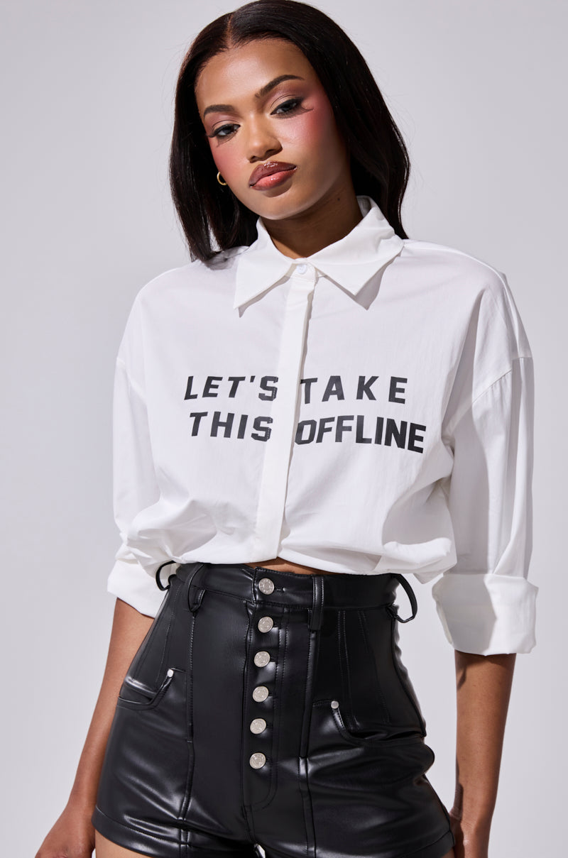 A woman with long dark hair wears the LETS TAKE IT OFFLINE BUTTON DOWN shirt and high-waisted black leather shorts, posing against a plain light background. 0