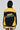 Someone is wearing a black and yellow MADE EXTREME OVERSIZED BOMBER, showcasing sports-inspired graphics and colorblock sleeves. The person faces away from the camera, emphasizing "Made Extreme" printed on the back of the jacket.