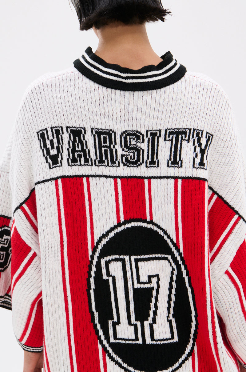 A person with short dark hair wears the THROW SUM MO KNIT JERSEY TOP, a varsity-inspired sweater in white, red, and black stripes with "VARSITY" and the number "17" in a large circle on the back. Their face is not visible.
