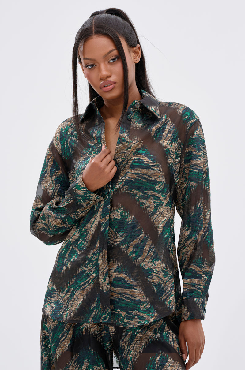 A woman with long dark hair wears the IN TOO DEEP BUTTON DOWN TOP and matching pants, standing against a plain light background, looking slightly to the side.