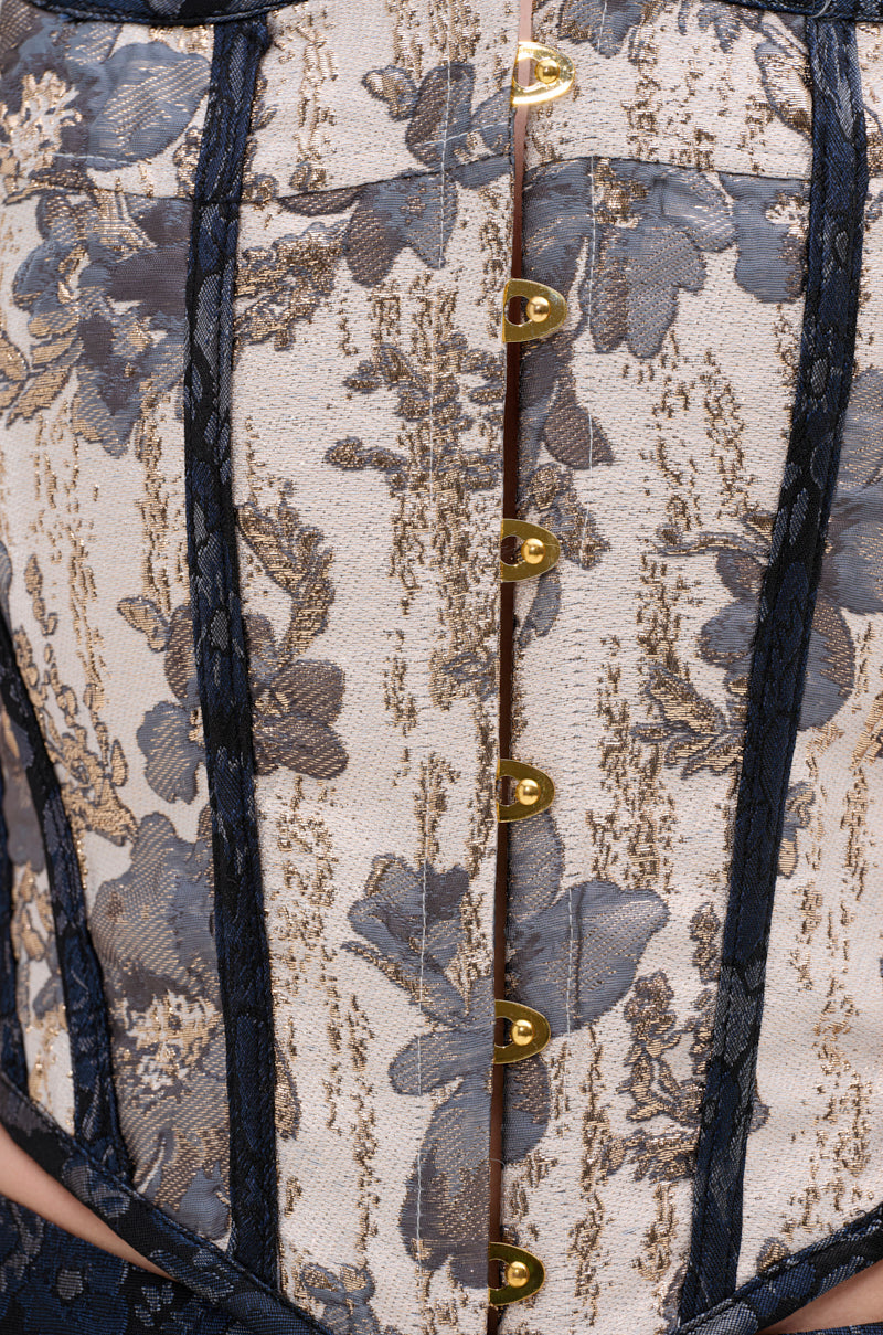 Close-up of the WON'T STOP MOVING BROCADE CORSET, featuring gold and blue metallic floral patterns, vertical navy trim, gold hook-and-eye front closures, and a classic lace-up back. 8