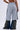A person wearing SEE YOU NEXT TUESDAY PANT, featuring gray sweatpants with contrast stripes over loose denim-camouflage panels, shown from the back in an image cropped above the waist.