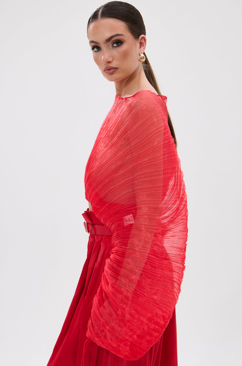Woman wearing the vibrant red FORTUNE'S FAVORITE ORGANZA CROP TOP with a structured, sculptural design. She has slicked-back hair in a low ponytail and poses against a plain white background.