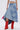 A person stands against a plain light background, showing only the lower torso and legs, styled in a white crop top, bright red boots, and the ALL WE NEED IS LOVE DENIM MIDI SKIRT.