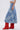 A person is shown from the side against a plain, light background wearing the ALL WE NEED IS LOVE DENIM MIDI SKIRT, a white sleeveless crop top, and bright red slouchy knee-high boots.