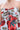 The ON VACAY PRINTED SATIN MINI DRESS showcases a strapless sweetheart neckline with a twisted bust knot and bold red and green rose print on light blue and coral satin, highlighting the shoulders and upper chest.