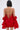 A woman with a short bob faces away from the camera in the CHIC AF RUFFLE MINI DRESS IN RED, featuring lustrous satin, ruffled sleeves, a halter neckline, and a textured skirt against a plain light background.