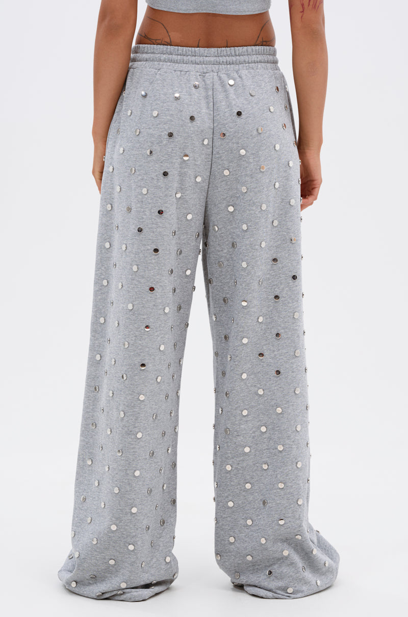 A person is shown from the back wearing POPPING OFF WIDE LEG JOGGER sweatpants in loose-fitting light gray with an elastic waistband and evenly spaced white and silver polka dots, set against a plain background. 5