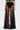 Wearing the MARA SHEER POLKA DOT MAXI SKIRT with a black and white crop top, high-waisted underwear, gold cuff bracelet, and black shoes with gold accents for a chic Parisian-inspired look. Shown from shoulders to feet.