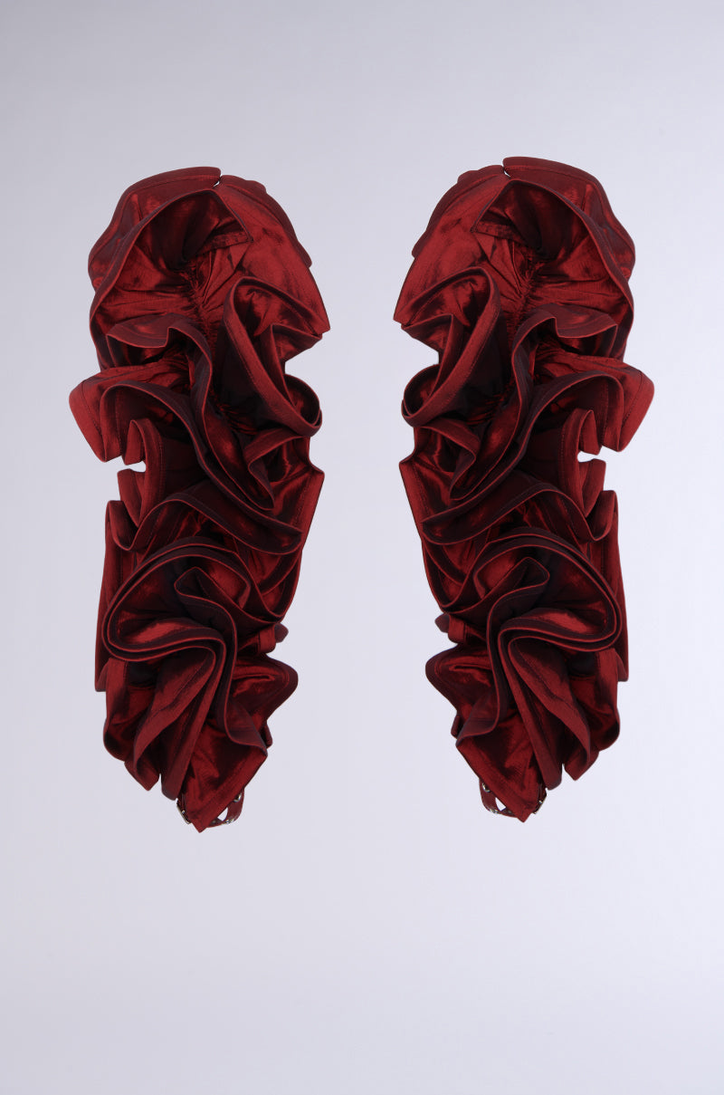 Resembling ruffled fabric or intricate roses, the SPREAD YOUR WINGS ARM SLEEVES are visually striking with their deep wine red color and abstract, vertically oriented design set against a plain gray background. The symmetrical, layered pattern evokes elegance akin to arm sleeves, creating a dramatic artistic effect.