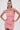 A woman stands confidently with her hands on her hips, wearing the LEXI FLORAL MINI DRESS—a sleeveless, curve-hugging mini in light pink, detailed with textured 3D floral appliqués—set against a plain white background.