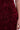 A close-up of a person wearing the GARDEN PARTY FLORAL MIDI DRESS in wine-red, adorned with textured 3D floral patterns. The person’s arm and hand appear on the right side of the image.