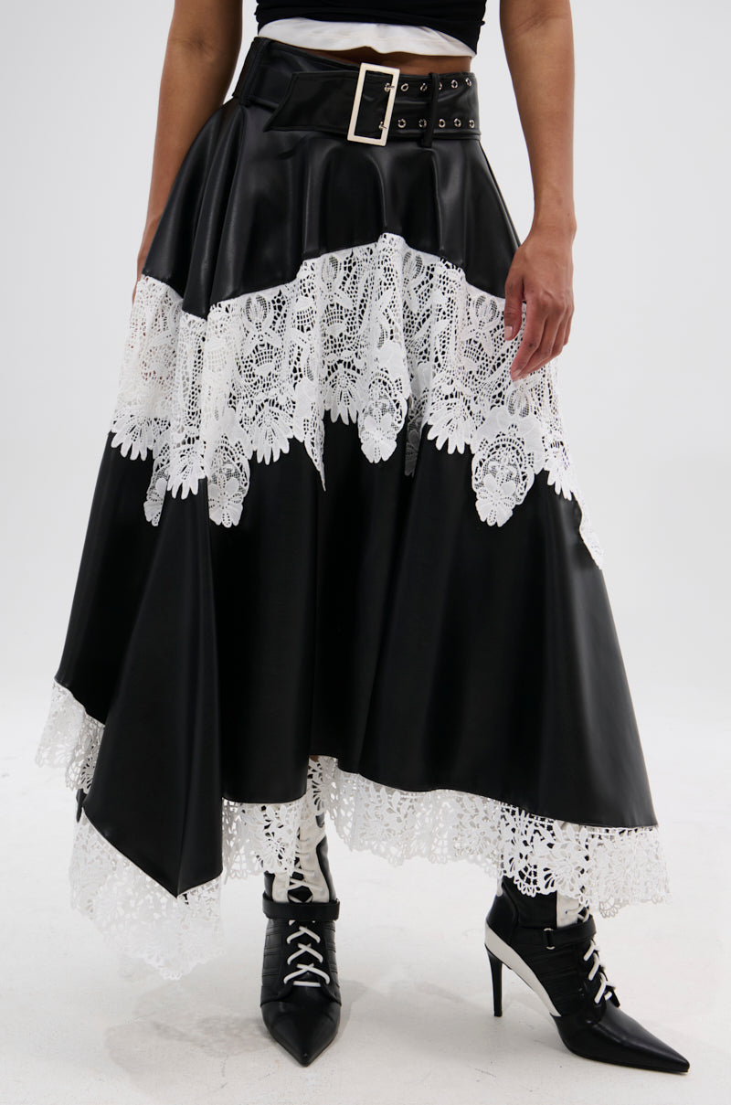Wearing the SARA BELTED LACE TRIM SKIRT featuring white lace panels and a wide silver-buckle belt, paired with black lace-up pointed-toe heeled boots, creates a chic blend of leather and lace textures.
