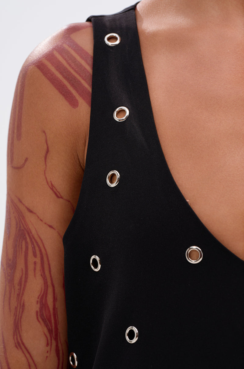 A close-up of a person in the ONE OF A KIND MINI DRESS WITH METAL HARDWARE, showcasing abstract red body paint on their shoulder and upper arm.
