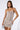 A woman stands confidently in the MEET ME ON THE DANCEFLOOR RHINESTONE MINI DRESS, featuring a strapless design and bodycon fit. She holds a small, silver clutch, has straight, long hair, and gazes directly at the camera against a plain background.