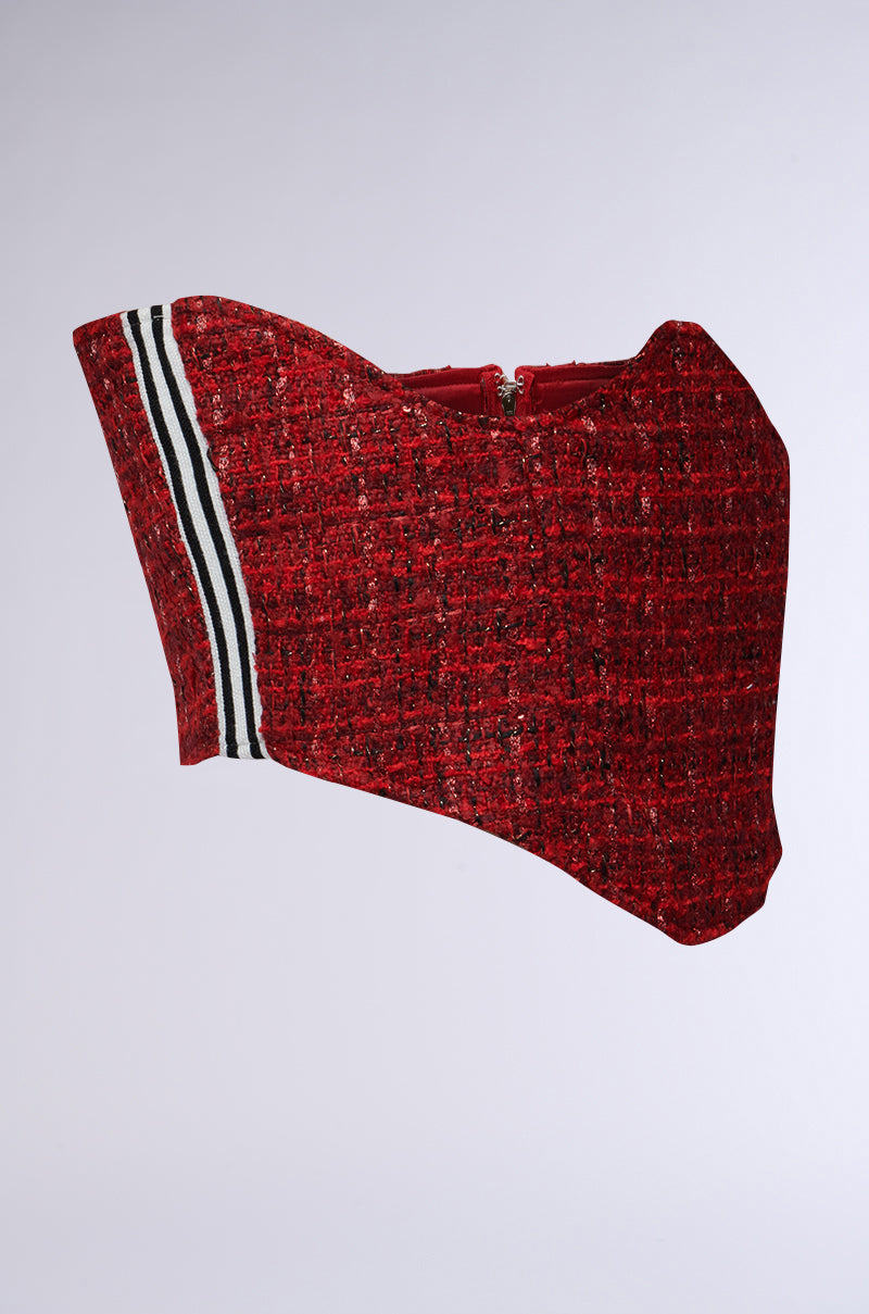 A vibrant red Tweedy Underbust Corset Belt showcasing a slight curve with an asymmetrical design. The piece features a metallic back zipper closure and is finely detailed with black and white stripes along one side, infusing a sporty touch to its sophisticated look.
