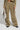 The individual is dressed in Stealthy Corduroy Cargo Pants, showcasing a wide-leg silhouette with multiple pockets and straps. They complement this ensemble with a gray patterned bag and gray sneakers that have black soles, resulting in an effortlessly cool appearance.