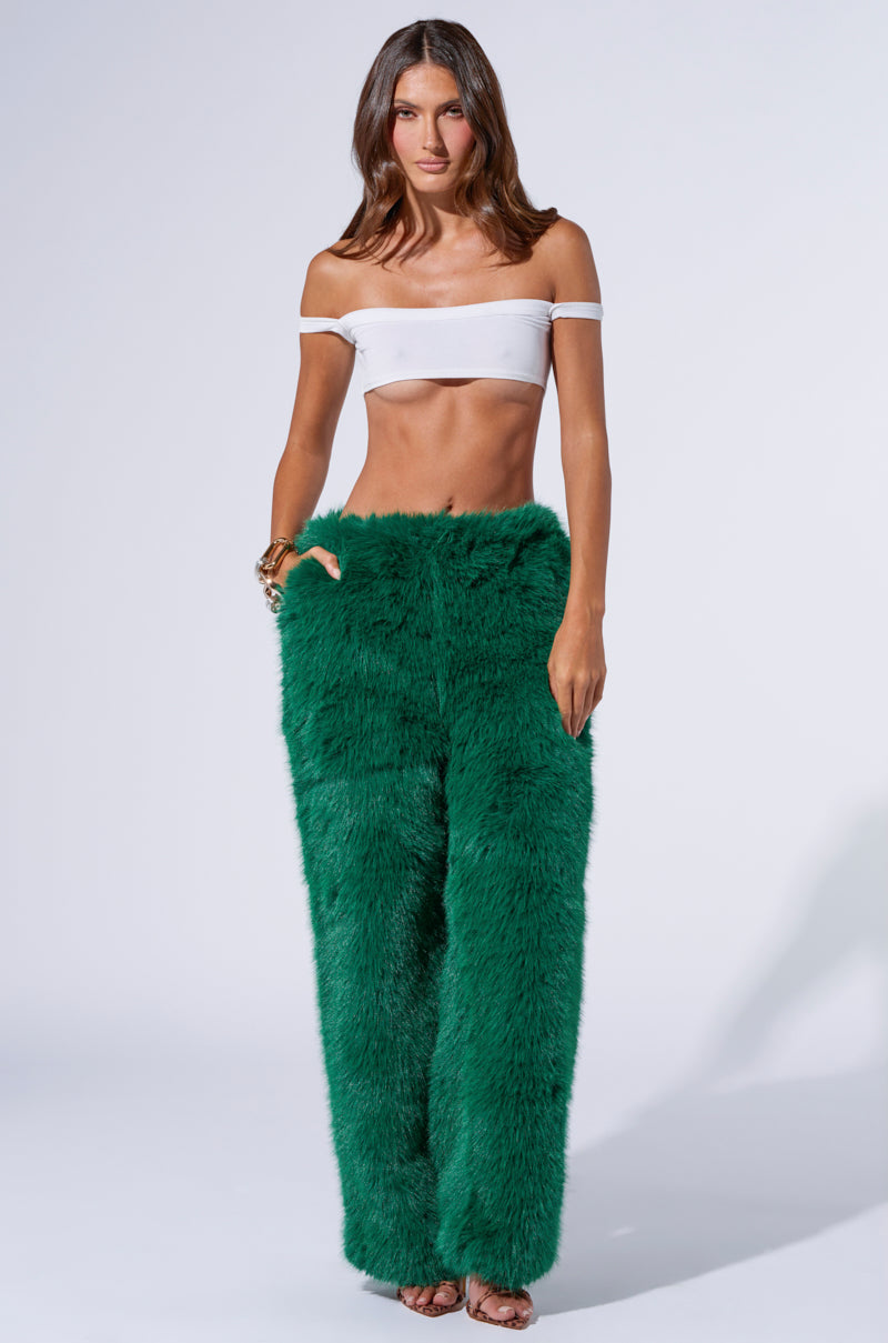 A person is modeling an off-shoulder, white crop top paired with the SEEING GREEN WIDE LEG FASHION FUR PANT. The outfit is bold and stylish, set against a plain, light-colored background. The person stands confidently, showcasing the unique texture and vibrant green color of the wide-leg pants.