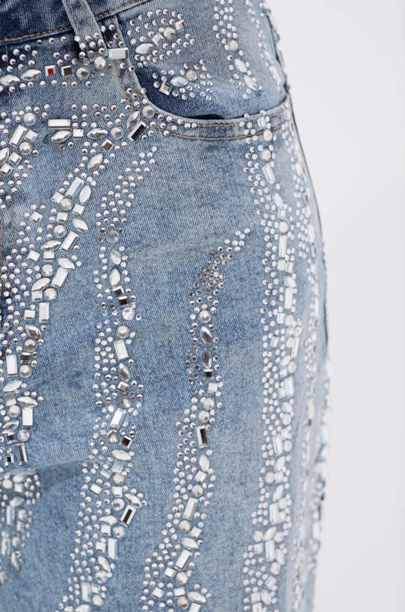 Close-up of the DIAMONDS DANCING DENIM FLARE PANT, featuring blue denim embellished with sparkling rhinestones in wavy vertical patterns—an ideal choice for adding glamour to jeweled flare jeans.