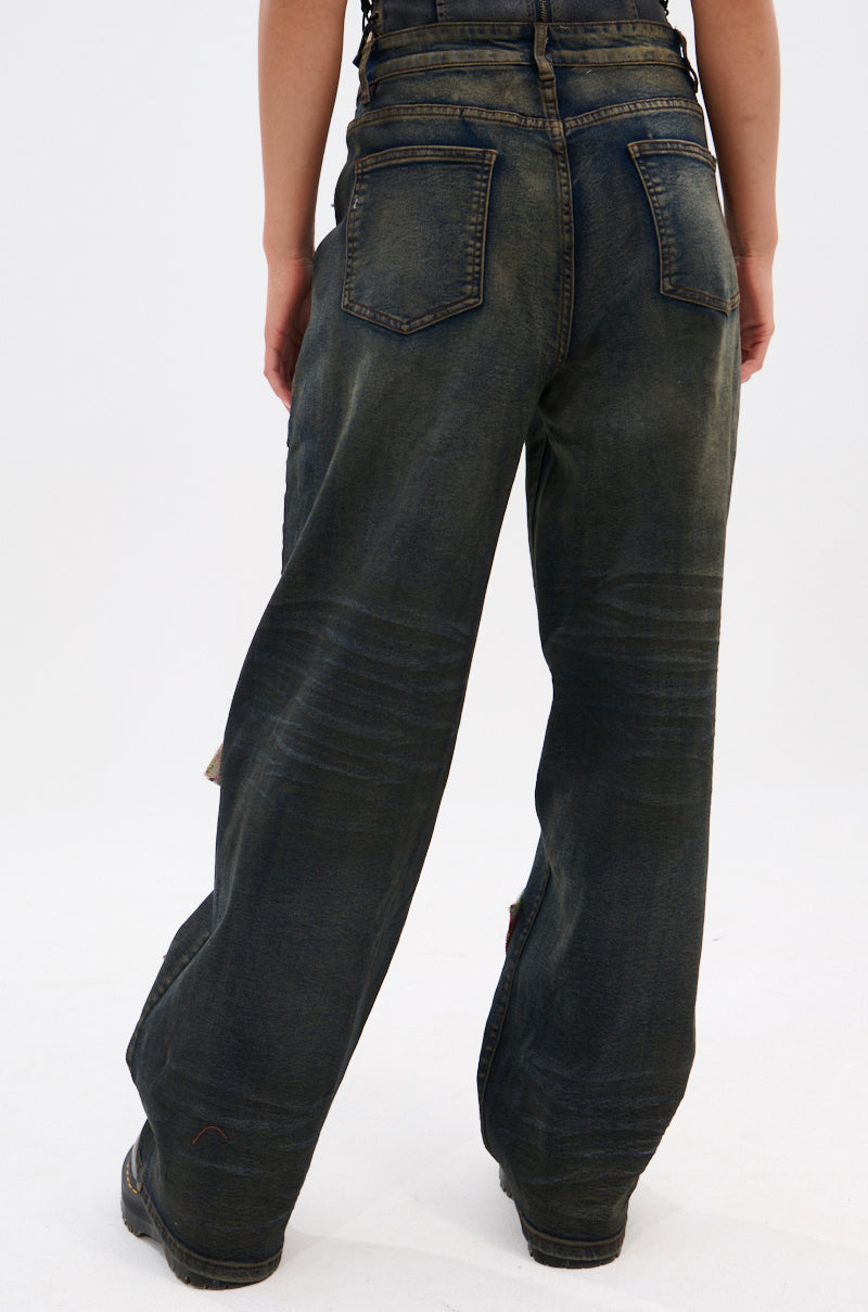 A person is seen from behind in ARTS AND CRAFTS PATCH WORK DENIM PANTS, which are vintage dark-wash, loose-fitting, high-waisted jeans with back pockets, set against a plain white background.