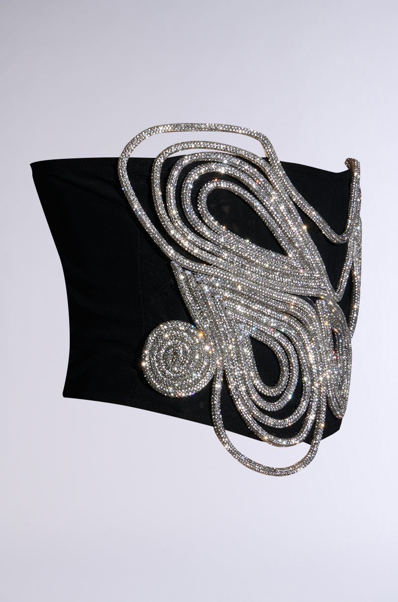 The IM A WONDER RHINESTONE STRETCH BELT, a black strapless top with corset inspiration, is embellished with a detailed pattern of shimmering silver rhinestones arranged in a coiled, abstract design. This waist-cinching accessory enhances any outfit with its mesmerizing sparkle.