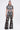 A woman faces forward in the FLORAL SEQUIN MESH SHORT SLEEVE BLOUSE and matching high-waisted pants with bold white floral embroidery, black sandals, hair pulled back, against a plain white background.