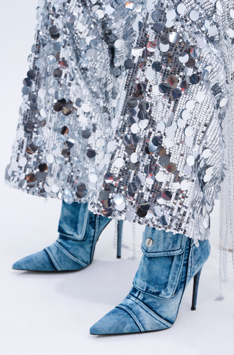 The denim high-heeled boots feature pointed toes and are perfectly matched with the EXPENSIVE TASTE STRETCHY SEQUIN CHAIN PANTS, which are decorated with large silver sequins and chain link details, offering a dazzling textured look.