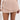 A person in the POETRY IN MOTION pleated mini skirt and a white crop top holds a cream handbag against a plain light gray background.