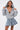 A woman poses confidently in streetwear style, wearing the FELT CUTE SWEATSHIRT DENIM MINI DRESS with oversized sleeves and a skater silhouette against a plain white background.