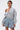 A person with short brown hair wears the FELT CUTE SWEATSHIRT DENIM MINI DRESS while facing forward against a plain white background.