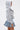 A woman stands in profile against a plain background, wearing the FELT CUTE SWEATSHIRT DENIM MINI DRESS with the hood up for a stylish, relaxed loungewear streetwear look.