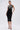 Wearing the MAYBE SOMEDAY MIDI DRESS WITH FLOWER APPLIQUE, she stuns in its curve-hugging fit, thin straps, and bold black-and-white flower detail, paired with strappy heels and gold hoop earrings.