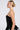 A woman with blonde hair styled in a neat bun poses in profile, highlighting the strapless design of her LADY FRIEND CORSET and silver floral skirt. The curve-hugging silhouette enhances her figure against the plain white background.
