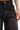 A close-up of a person wearing the STARS SHINING RHINESTONE BERMUDA SHORT, detailed with small, evenly spaced rhinestones. Their manicured hand with light polish rests near the pocket for a chic touch.