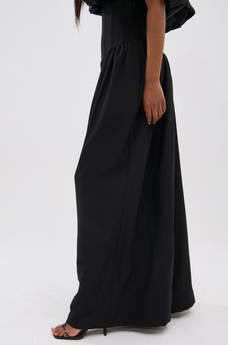 A person is shown from the waist down wearing the BETTER THAN THIS CORSETED TROUSER in black and black high-heeled sandals, standing against a plain white background.