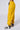 Side view of a person wearing the DONE WITH YOU JOGGER in bright yellow, featuring an elastic waistband and multiple cargo pockets. The joggers have elastic cuffs at the ankles and black lettering along the side. The individual is also wearing white and black sneakers.