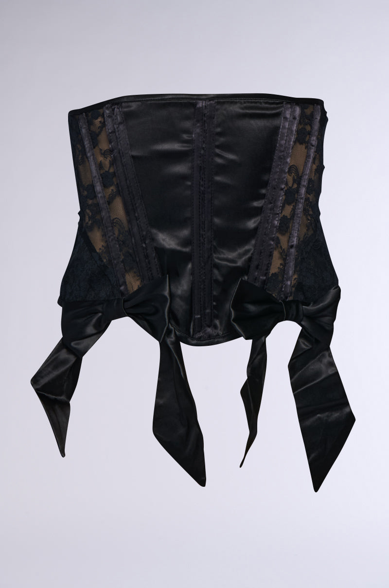 The COQUETTE COUTURE BOW BELT, with its black corset design featuring lace detailing and decorative satin bows at the bottom, exudes an air of elegance. This waist-snatching accessory is structured with vertical boning for a sophisticated silhouette.