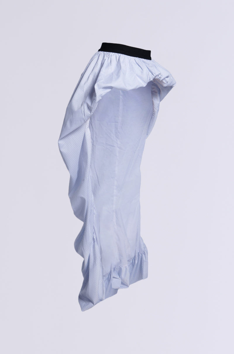 The RUNWAY BELT SKIRT is a flowy white skirt with subtle vertical stripes, showcasing a black waistband and an asymmetrical high-low silhouette with a ruffled hem, elegantly set against a plain white background.