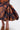 A close-up of a person wearing the LADY LUX BROCADE BUBBLE HEM MIDI SKIRT with metallic gold and orange dark floral brocade, a dramatic bubble hem, and strappy embellished heels.