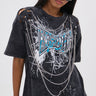 A woman in large black sunglasses and the KNOCK YOURSELF OUT DISTRESSED TEE, featuring chain and safety pin details, ripped shoulders, and a bold blue-and-white graphic. Her straight hair and confident look complete the grungy-chic vibe.