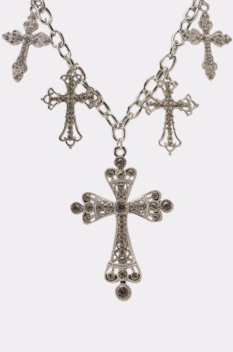 The STAY BLESSED NECKLACE features an oversized silver link chain adorned with five vintage-style, intricately detailed cross pendants, evenly spaced for a bold statement look. 2