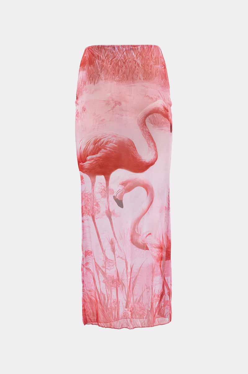 The IM A FLAMINGO SWIM COVER SKIRT is a long, fitted skirt with a pink and white design featuring two flamingos and grassy water plants printed near the bottom. 2