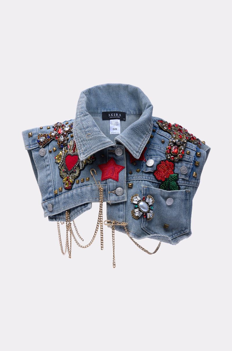 The STYLE ME UP DENIM COLLAR is a cropped blue denim jacket with classic collar, decorated with colorful embroidered patches, beads, gemstones, studs, rhinestones, gold chains, and ornate flower, heart, and star details. 2
